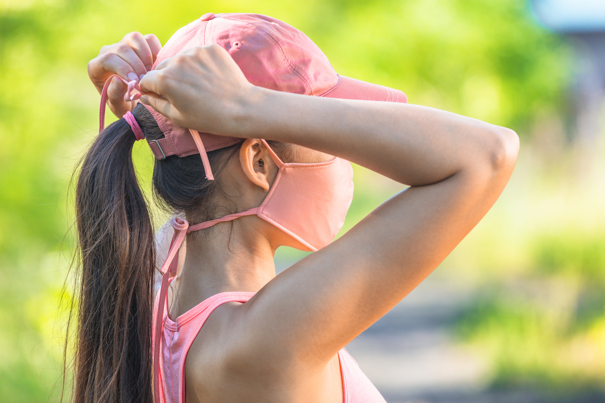 woman wearing coronavirus protection tying string ties to secure mask