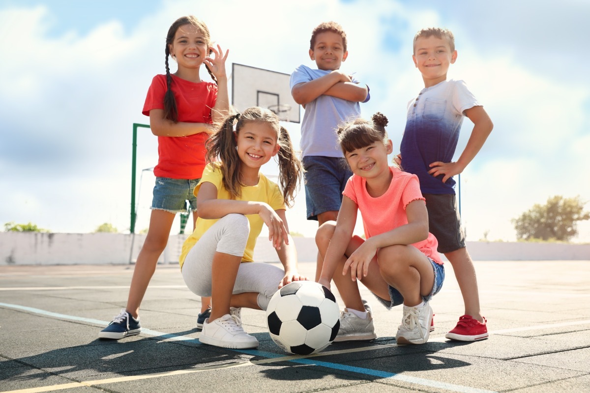 group of kids posing with a soccer ball