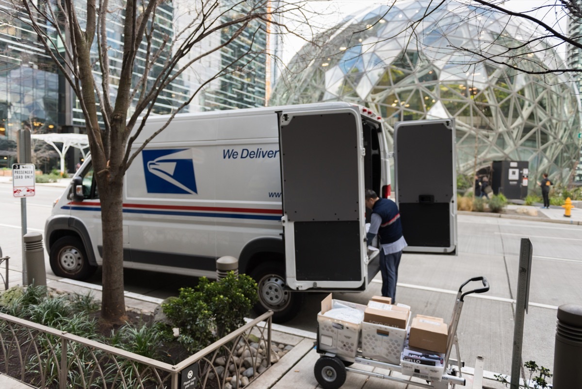 A USPS truck as a driver delivers packages on 6th avenue across from the Amazon Spheres in downtown late in the day.