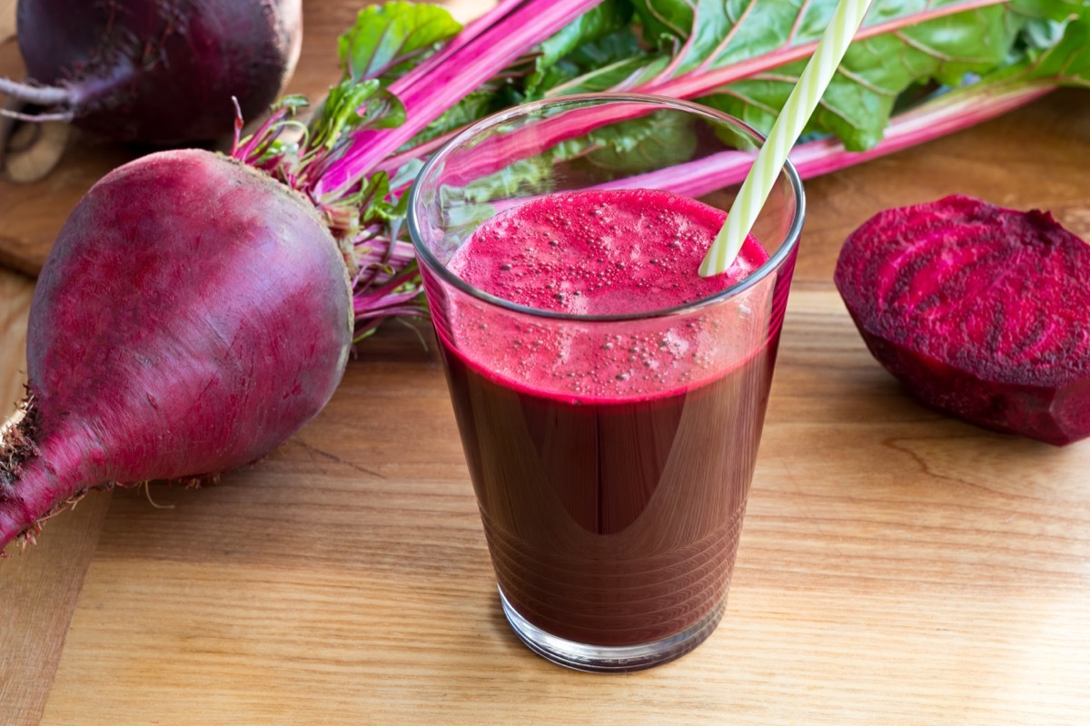 beet juice in a glass, straw, fresh beet