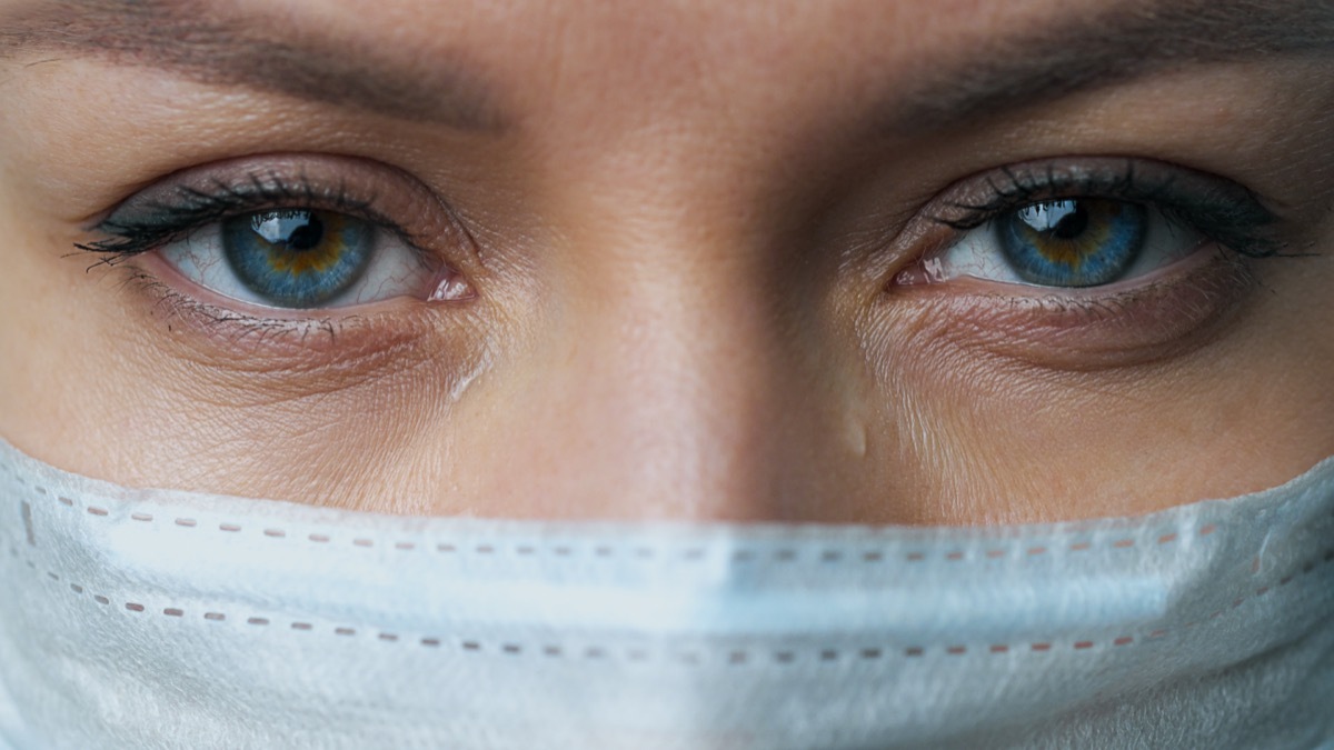 woman wearing mask with eyes watering