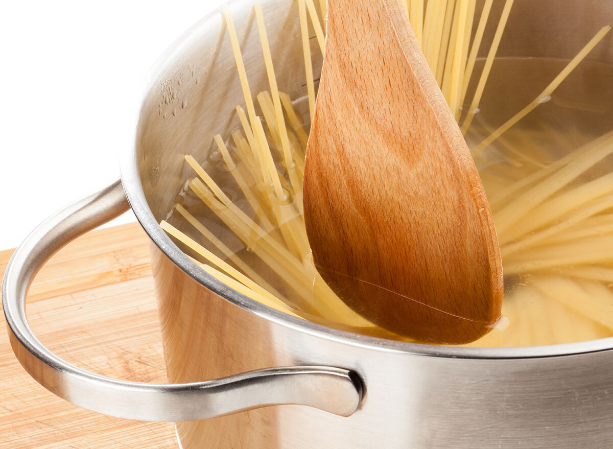 wooden spoon stirring pasta