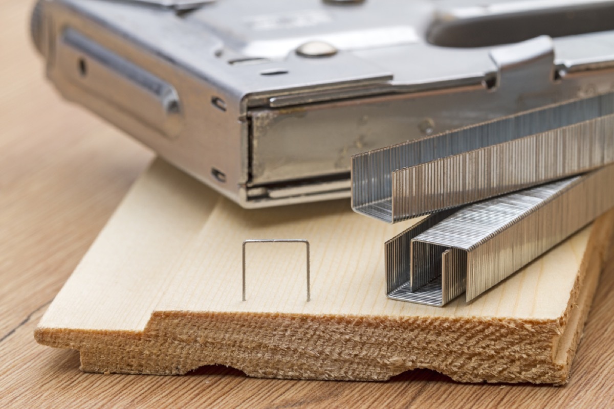 staple gun and staples on plank of wood