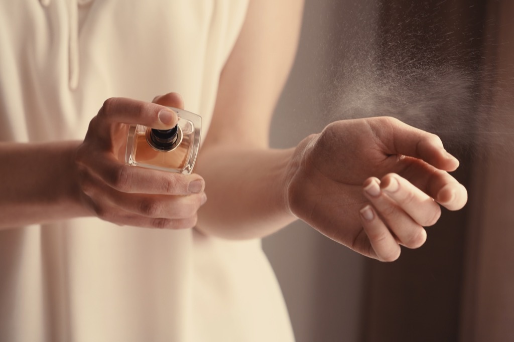 woman spraying perfume floral