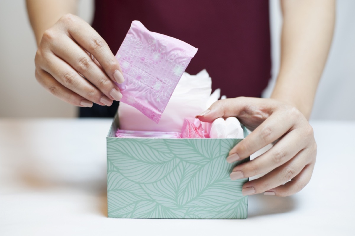 white woman removing pad from box 