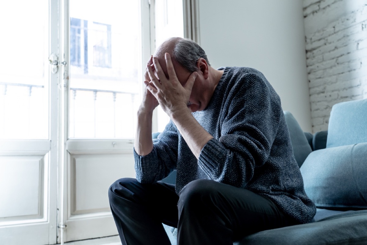 older white man with his head in his hands