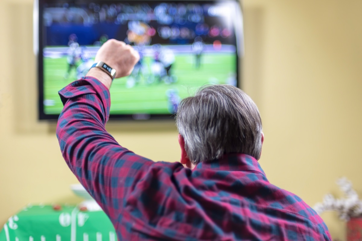 older man watching football