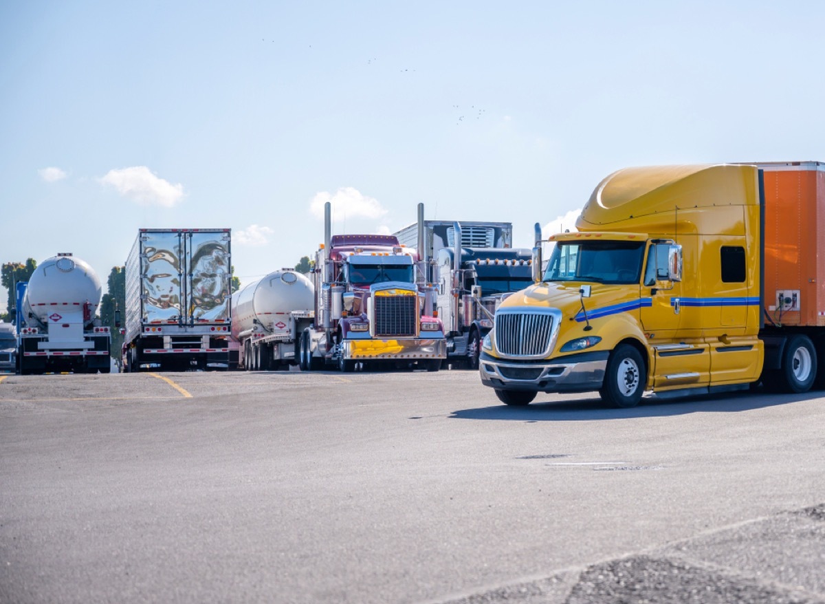 different long haul trucks parked in a lot