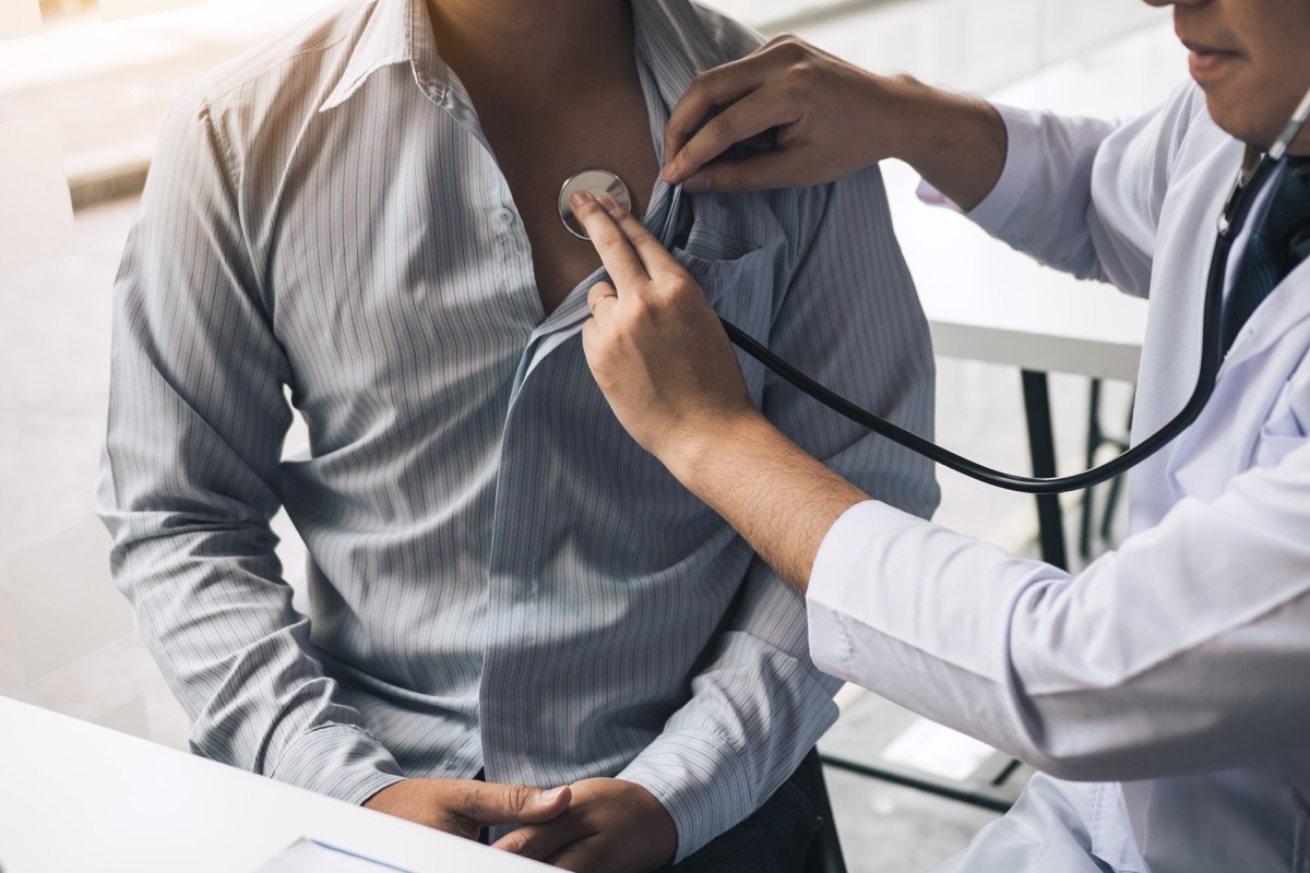 doctor is using a stethoscope listen to the heartbeat of the elderly patient.