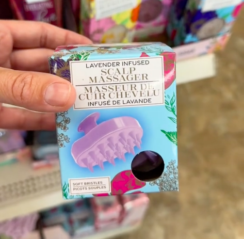 A shopper holds a lavender infused scalp massager while shopping for the best Mother's Day gifts at Dollar Tree.