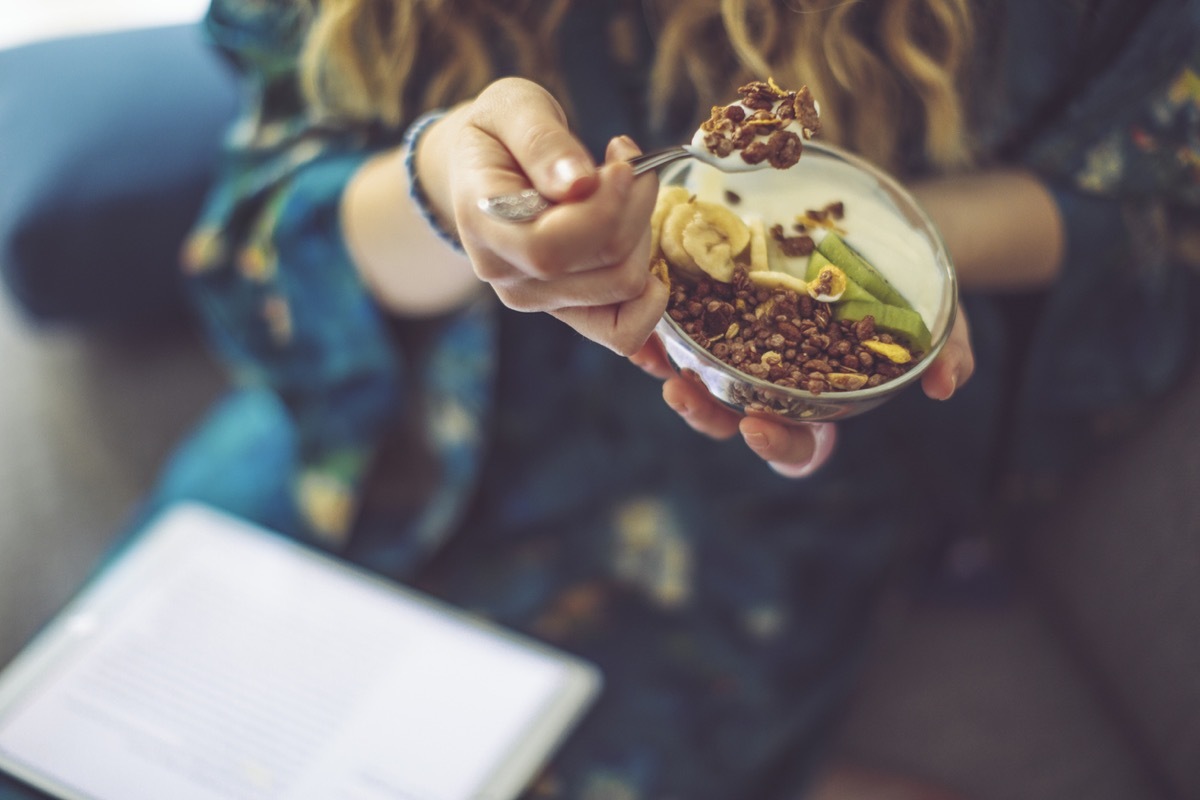 woman has small bowl of grains and yogurt