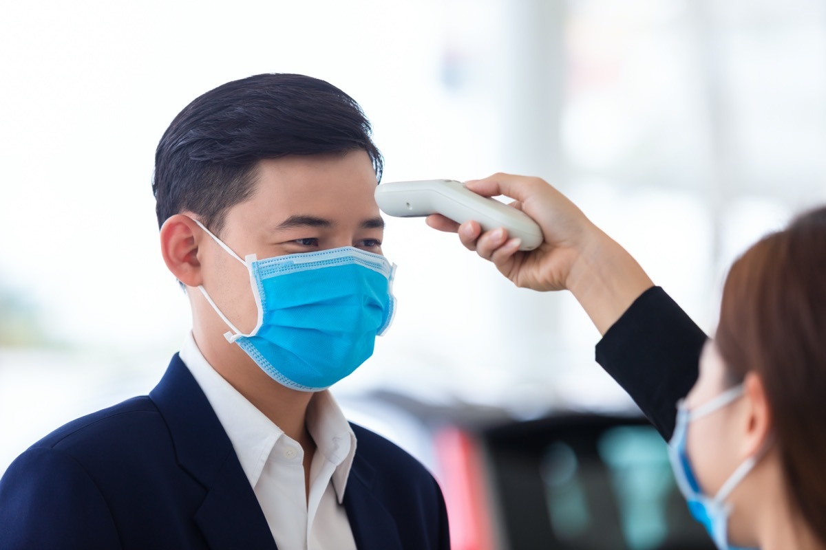 Woman taking man's temperature