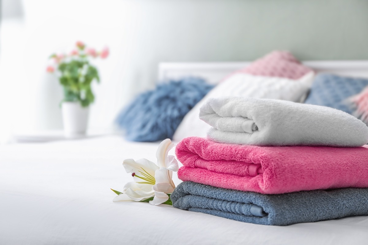 Stack of clean towels on bed