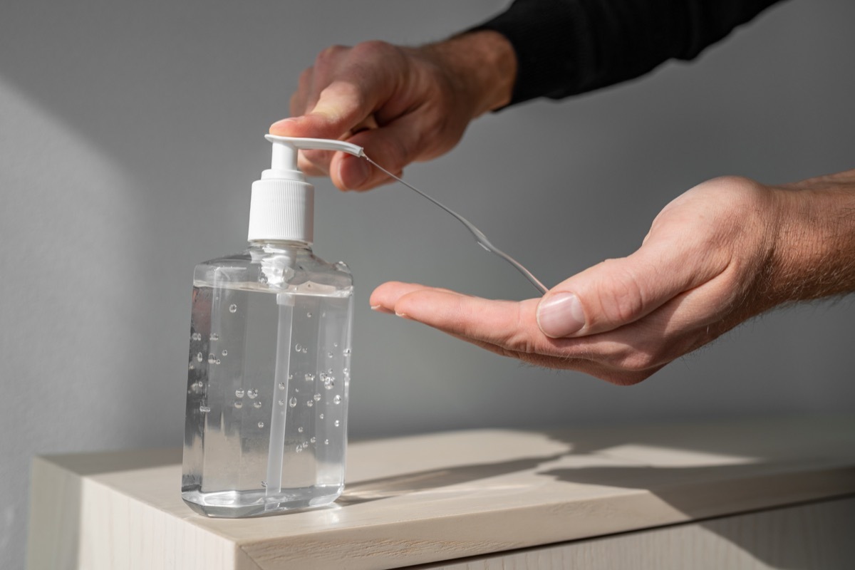 Hand sanitizer alcohol gel rub clean hands hygiene prevention of coronavirus virus outbreak. Man using bottle of antibacterial sanitiser soap.