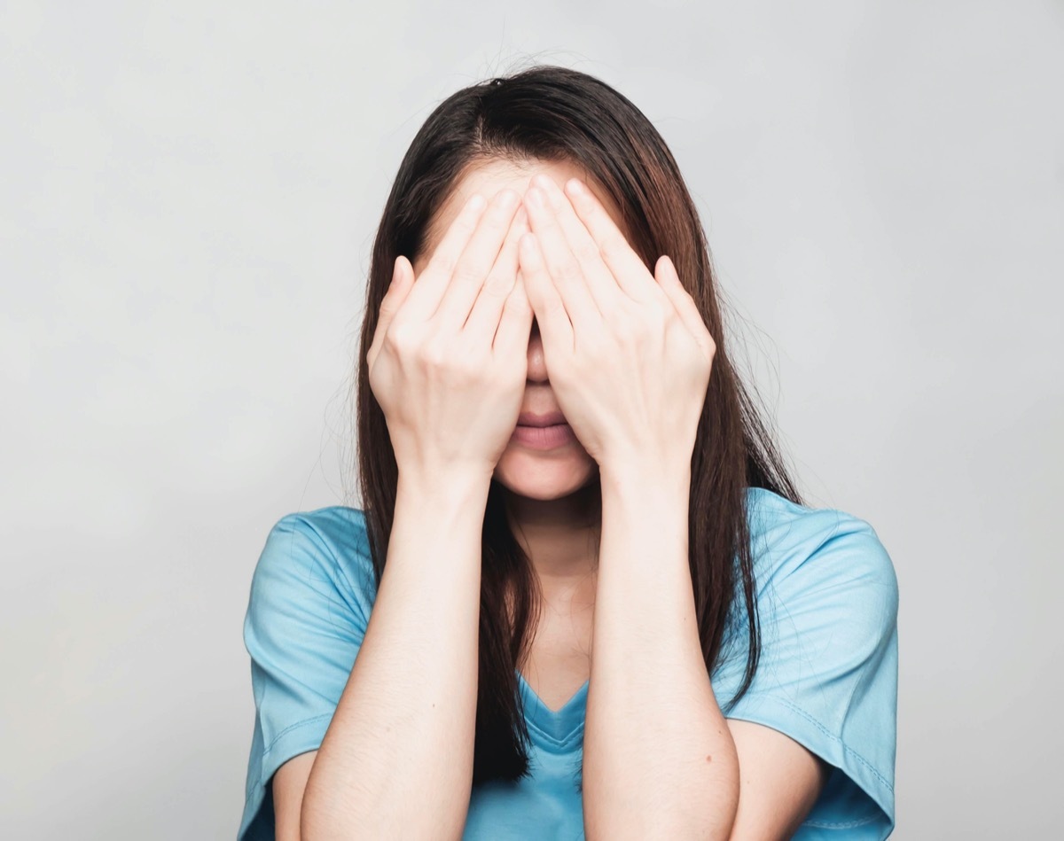 Woman covering eyes with her hands