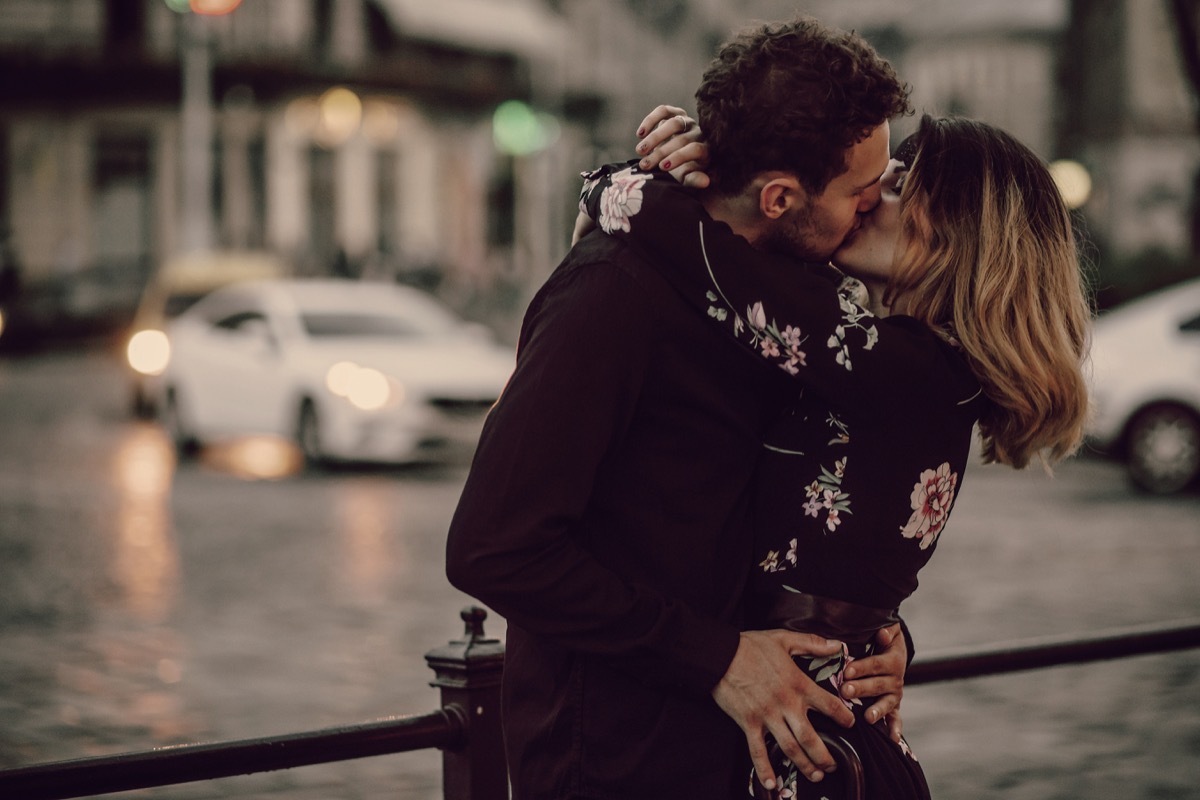 couple kissing on a bridge