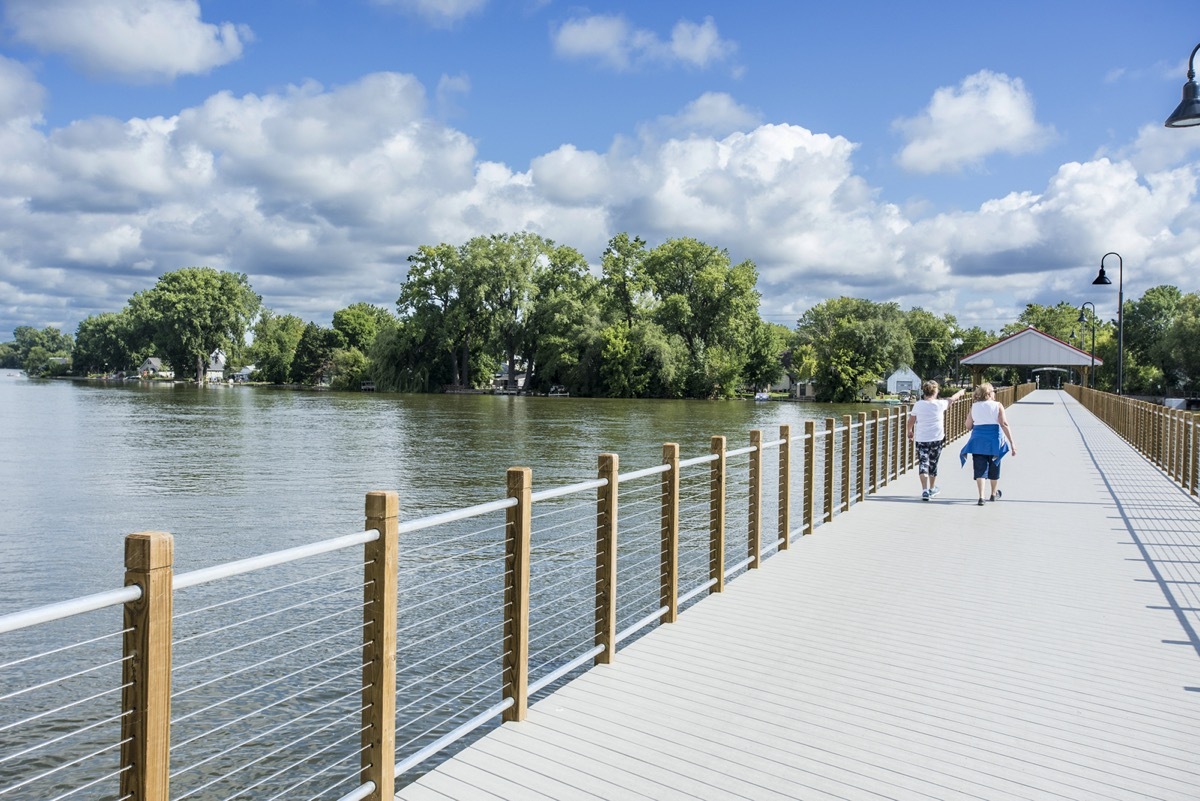 two women walking on a waterfront pathway