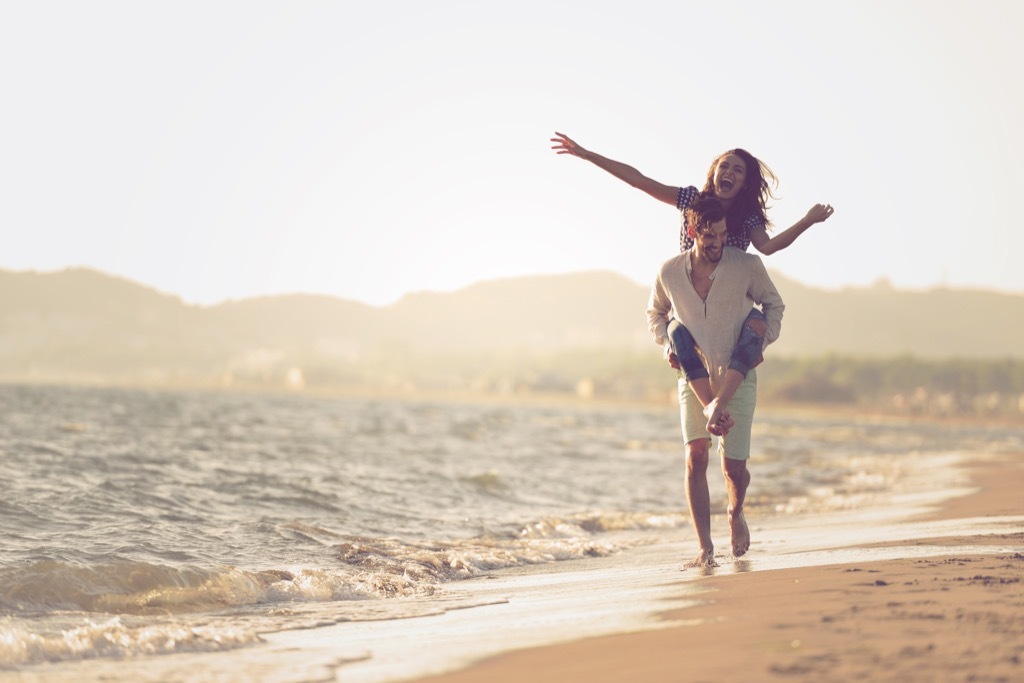 couple walking on beach feeling happiness