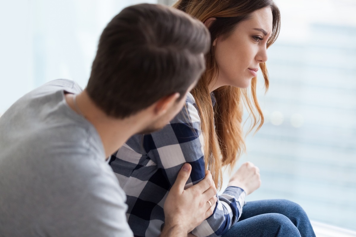 caring man leans to console woman who is upset