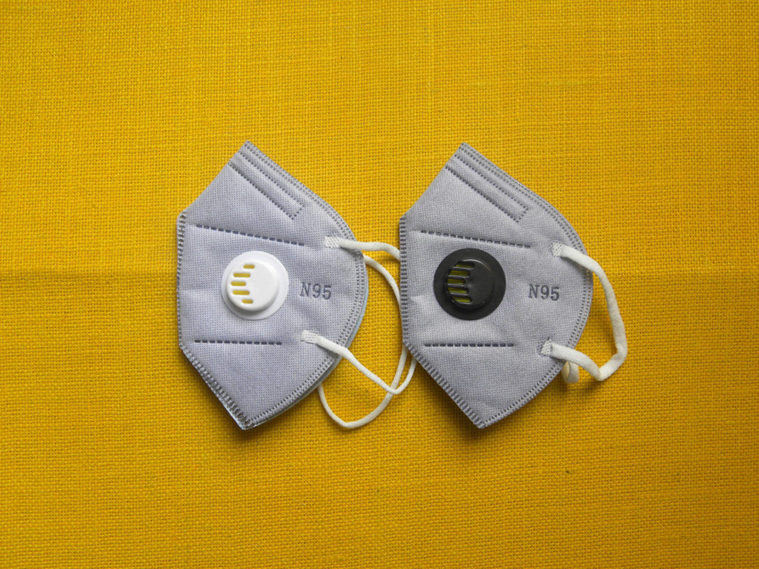 two gray fake n95 masks on yellow background