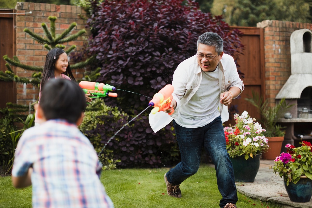 Asian family having a water fight