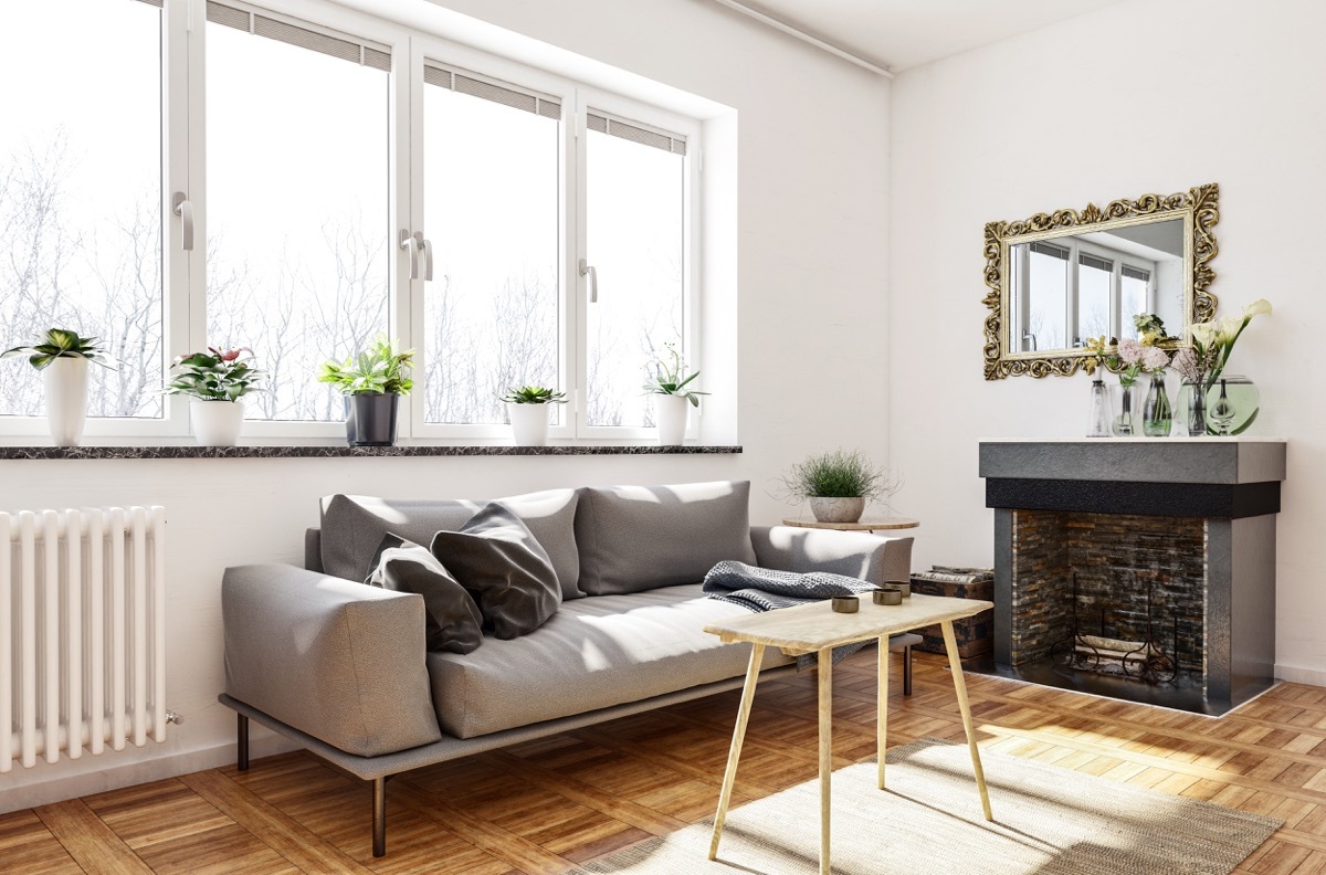 Living room with a lot of light coming through windows reflecting off of mirror