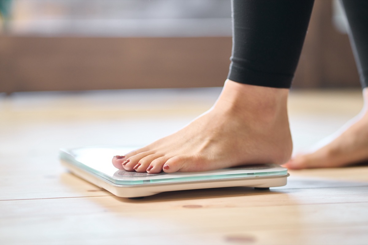 woman stepping on scale