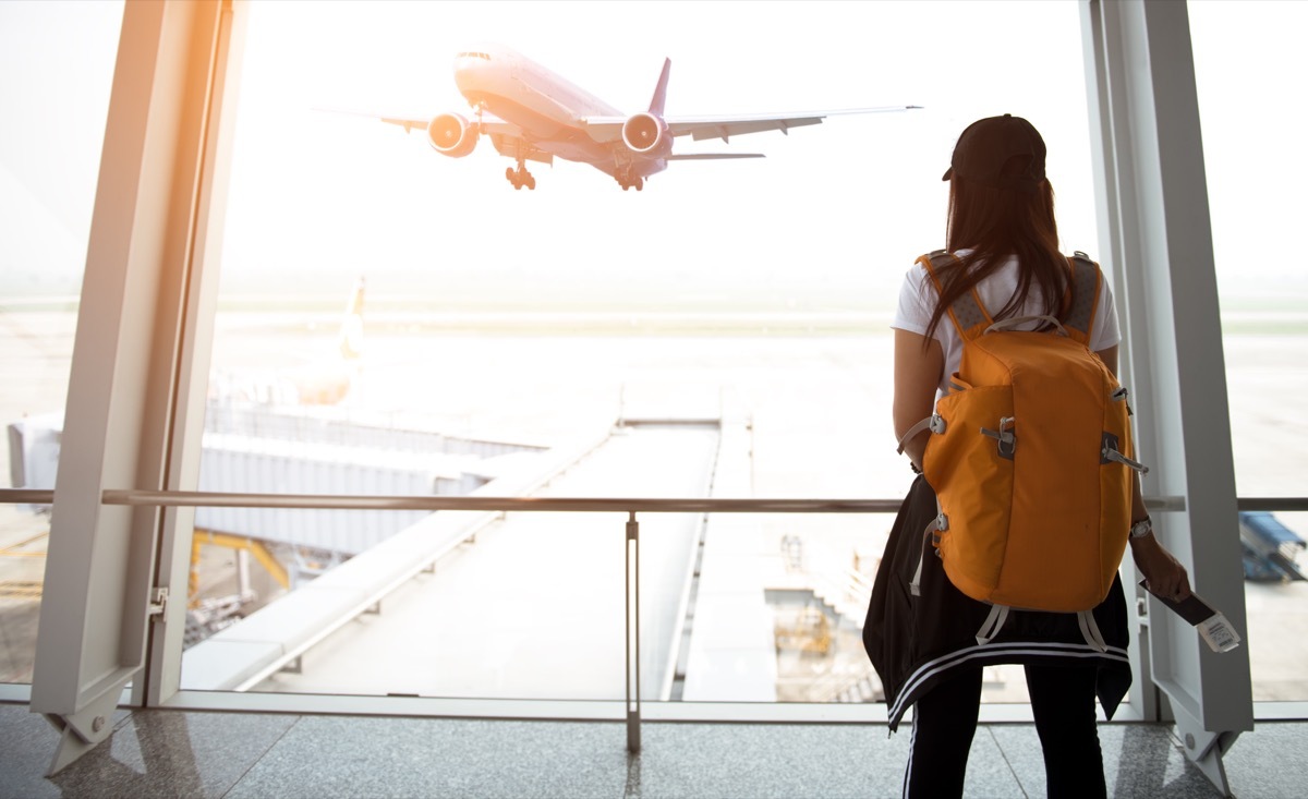 woman at airport watching plane