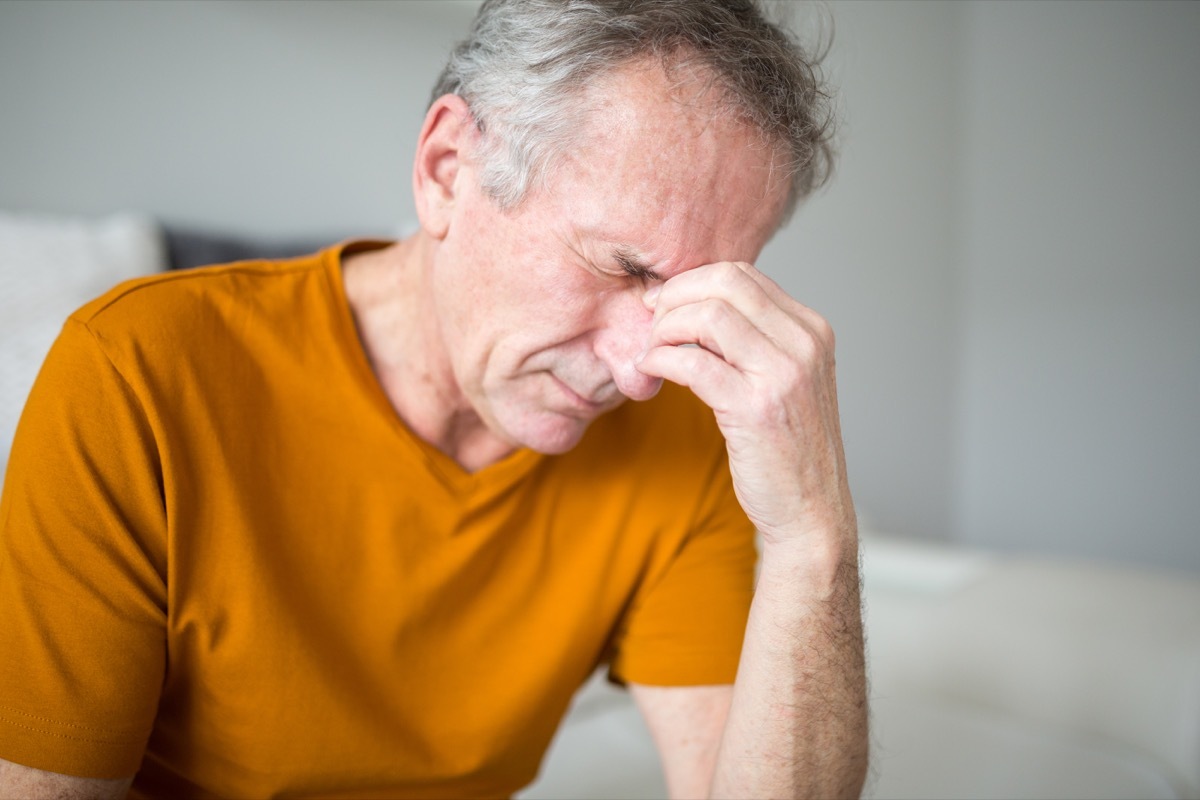 Portrait of senior man suffering from migraine or stroke