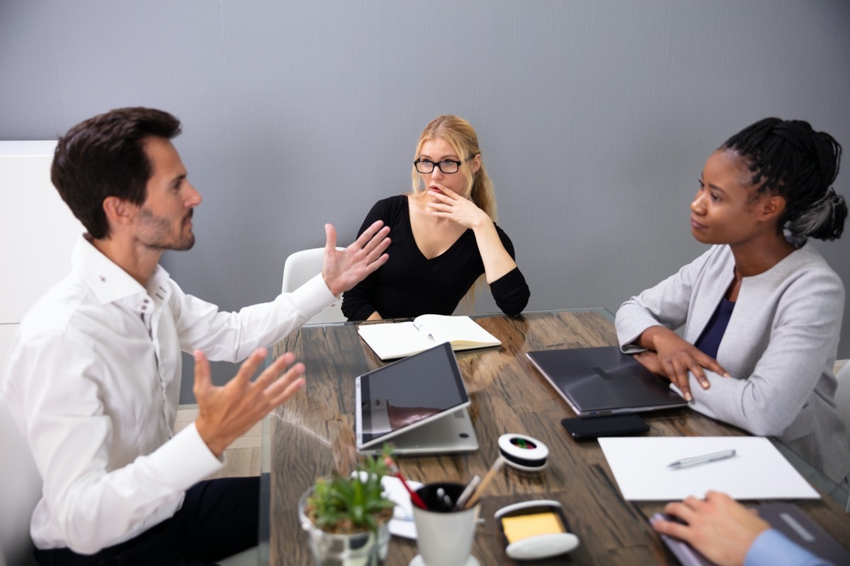 Man explaining something to two women in business meeting