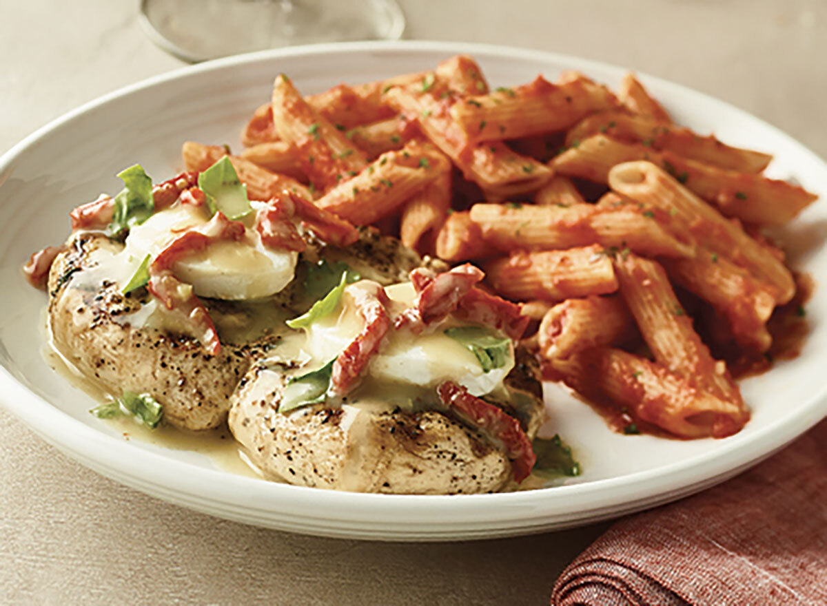 carrabbas chicken bryan with penne pasta on white plate