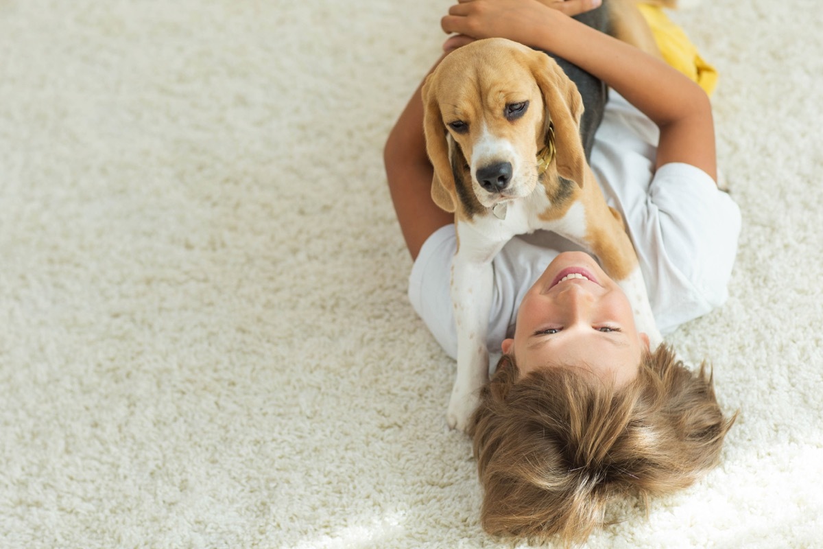 young boy wrestling dog