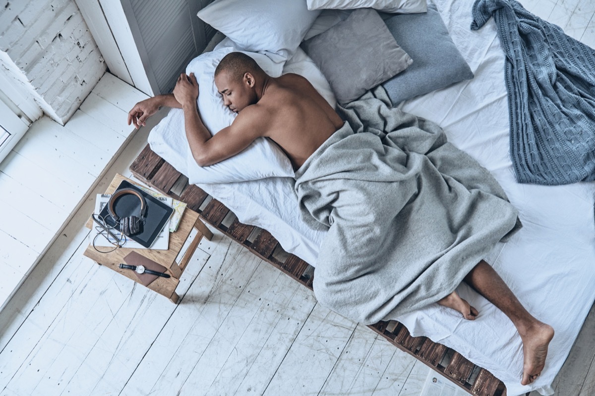 man sleeping on his stomach with his arms wrapped around a pillow - sleeping positions