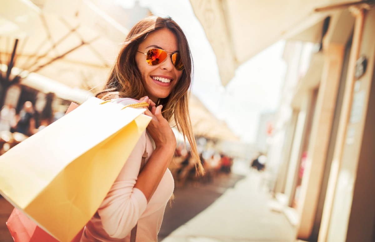 woman holding shopping bags and wearing sunglasses, end of summer sales 2019