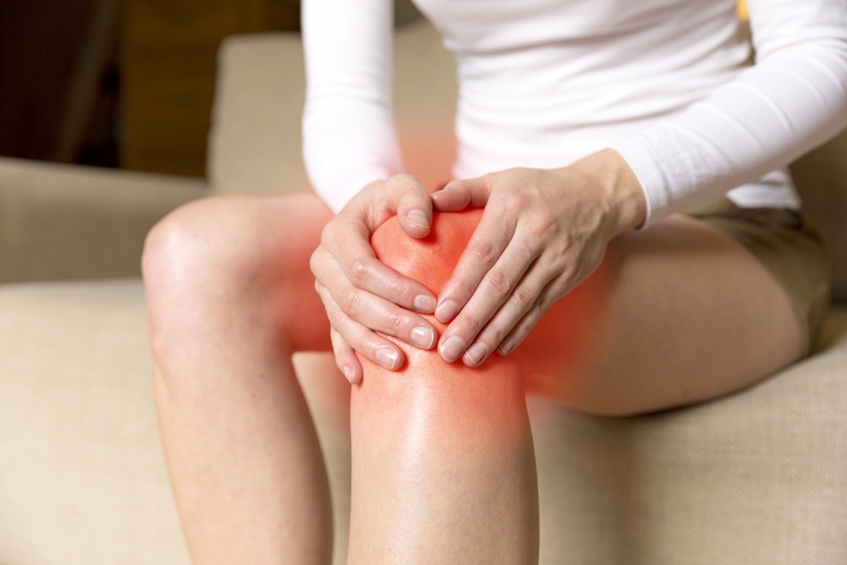 woman holding her knee because its painful and inflamed