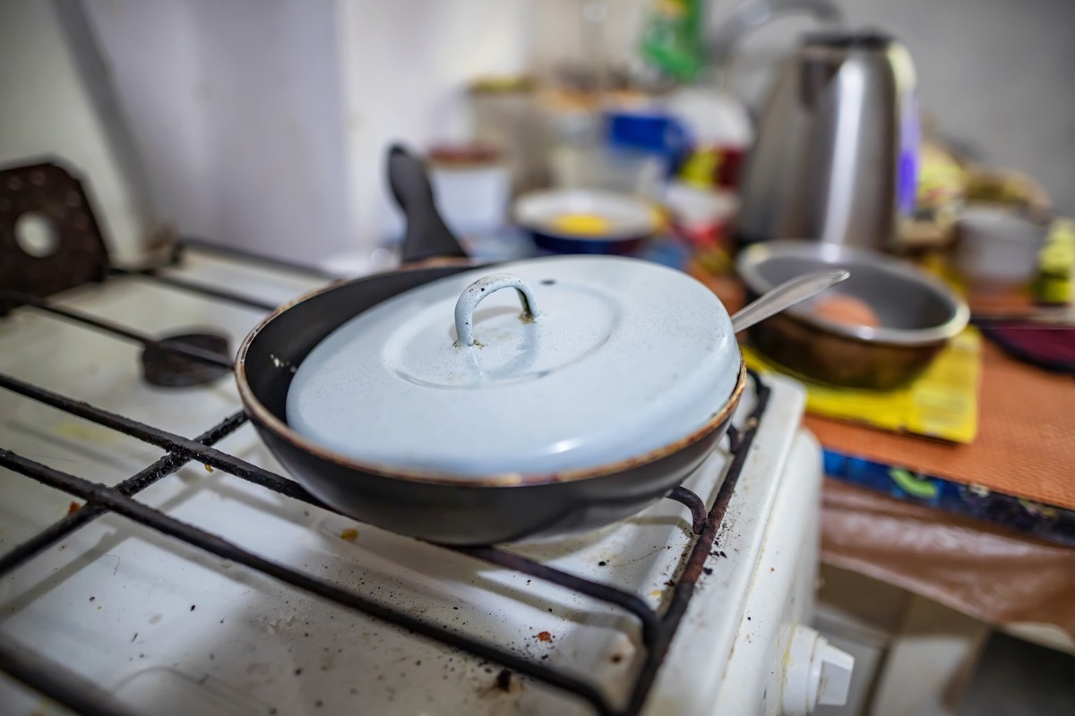 Old pan sitting on a burner on the stove