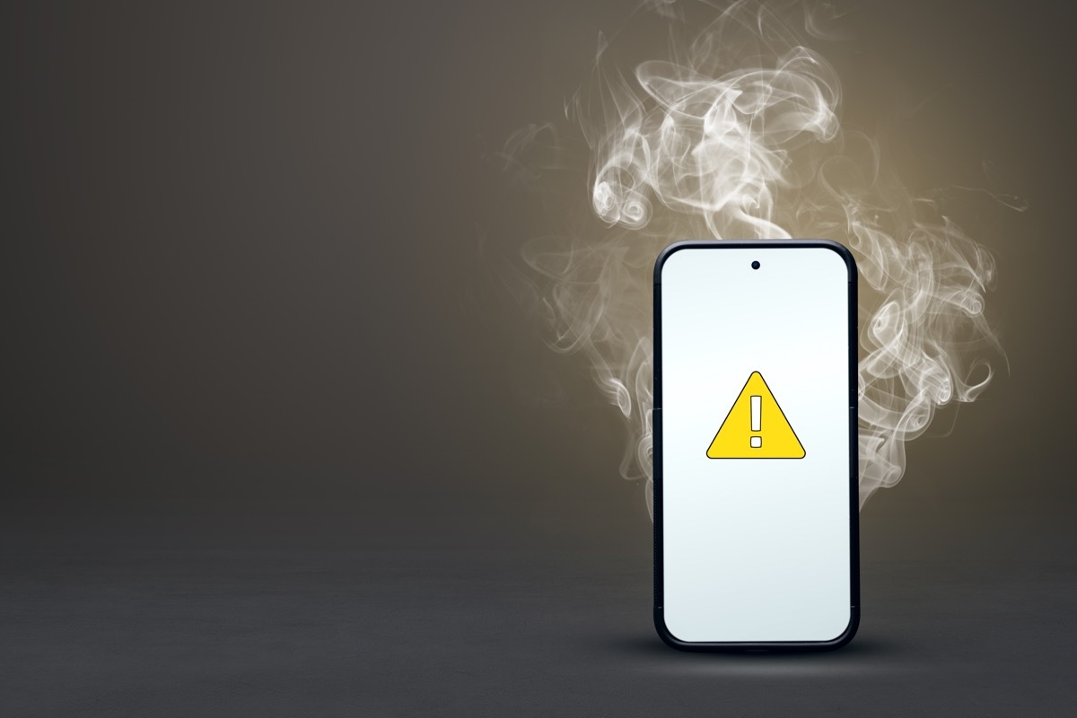 smartphone overheating with warning sign