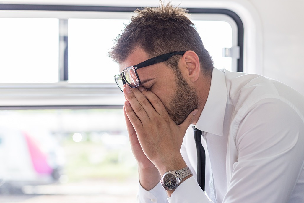 man stressed out and depressed on public transportation.