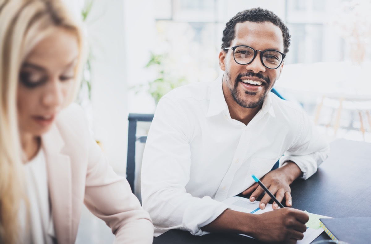 man at work smiling in thick eyeglasses, health questions over 40