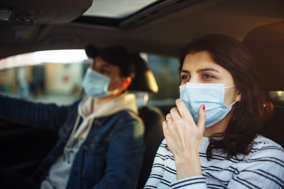 woman wearing mask coughing into hand