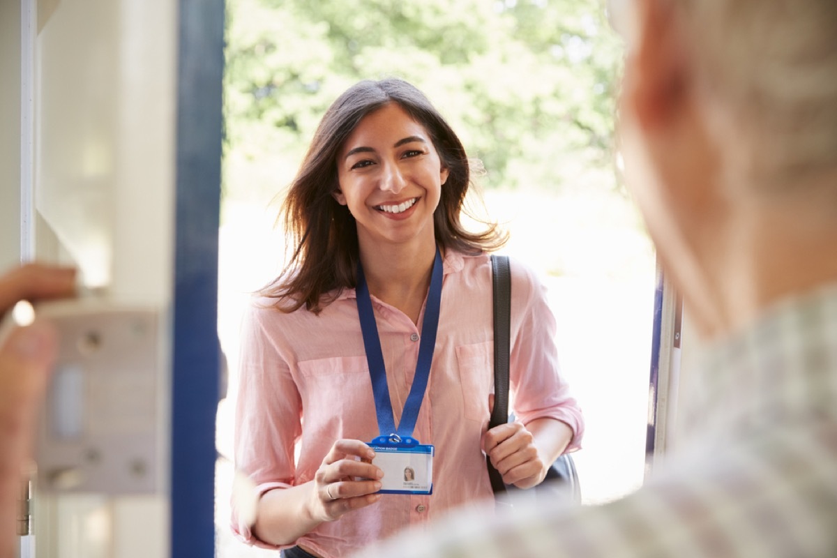 woman showing id to elderly man opening door