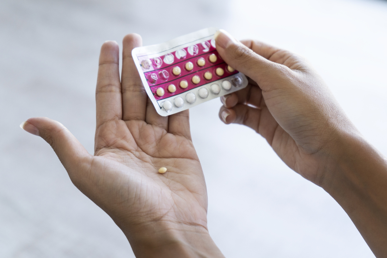 Woman holding birth control pills.