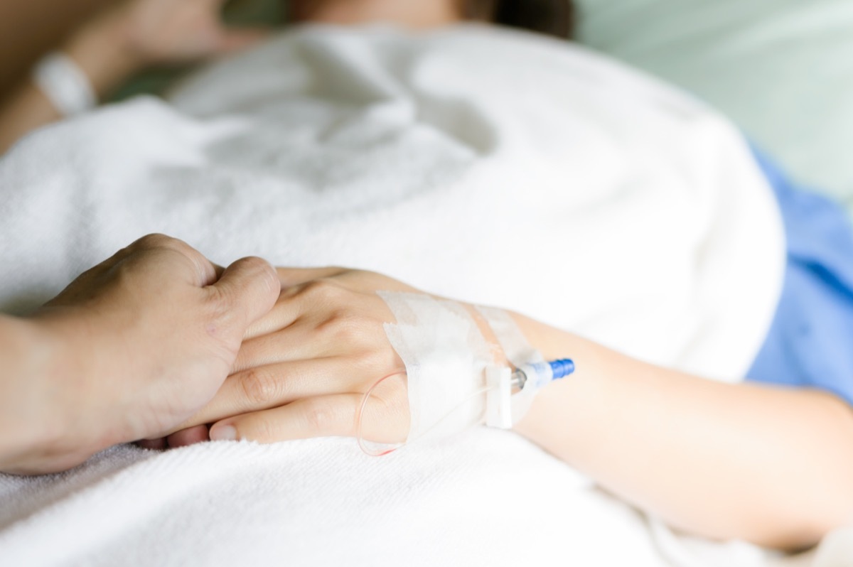 Holding hand in hospital bed