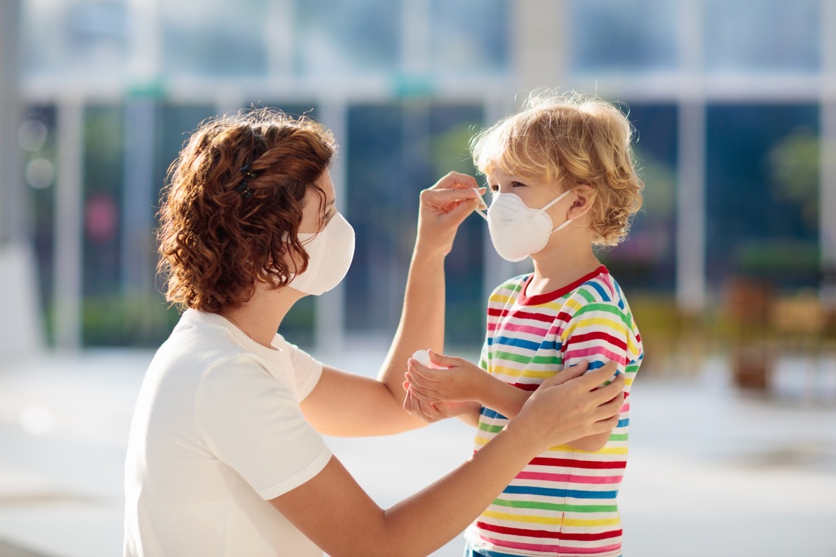 Mother putting a mask on her child