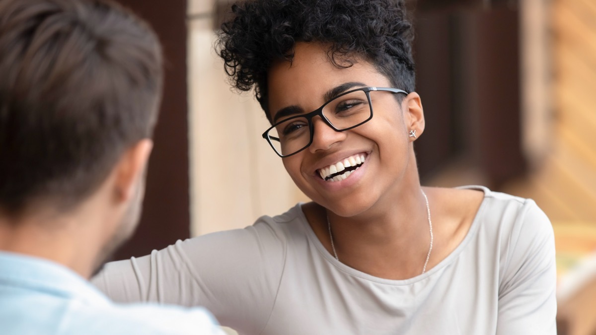 Black Person Smiling and Listening to Her Companion