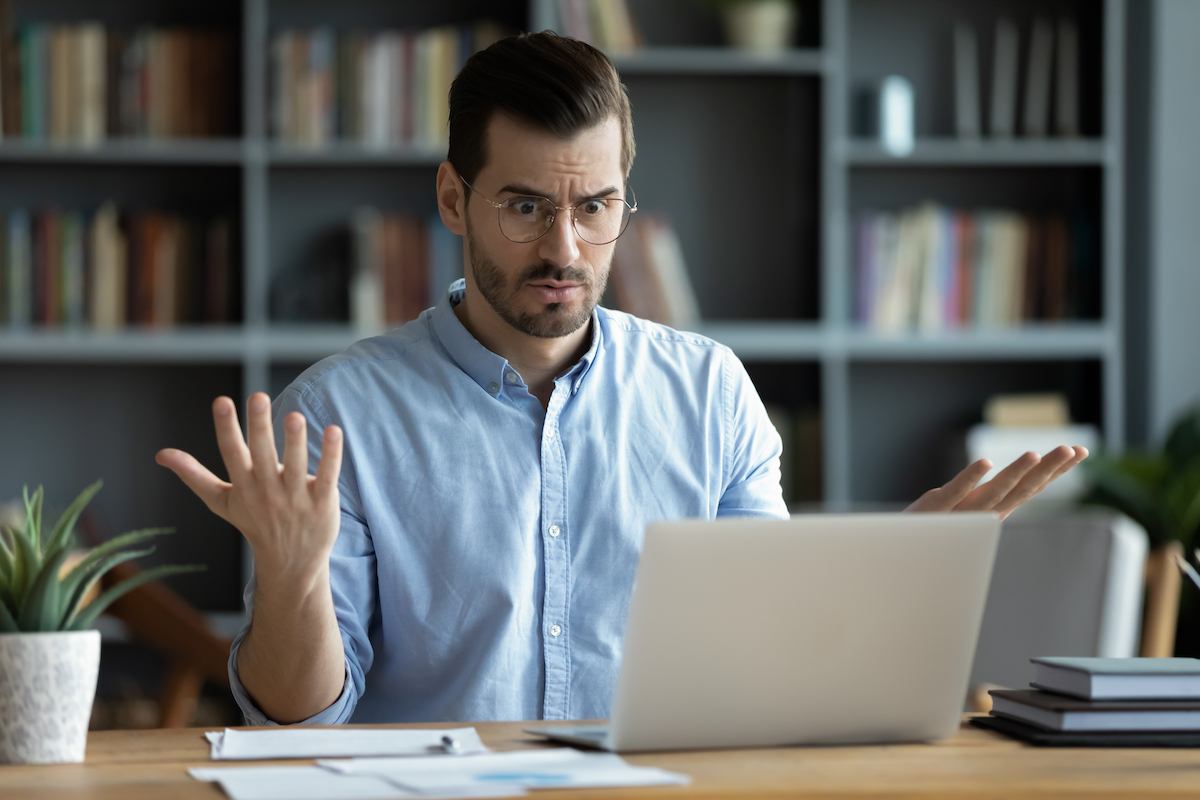 Confused man looking at his laptop