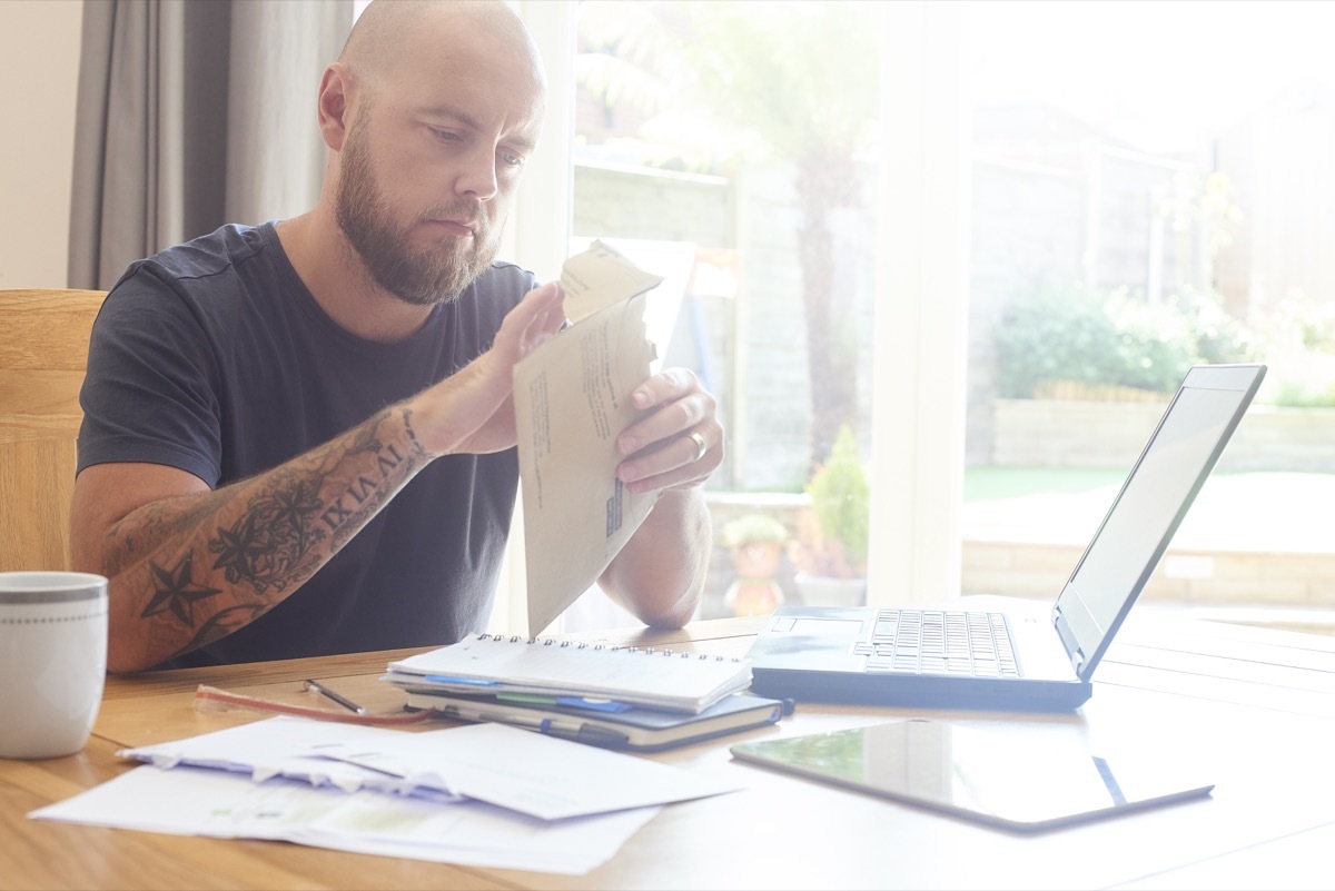 Man sat at dining room table working from home or sorting out home finances