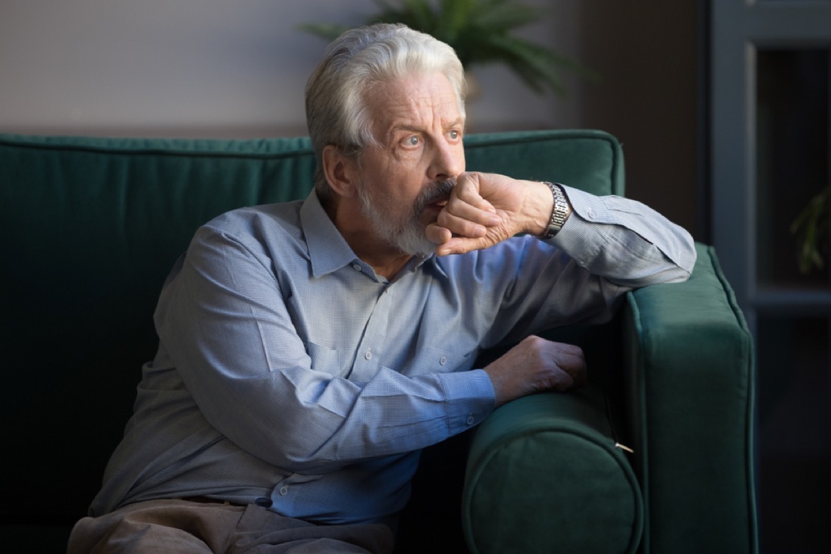 concerned older man sitting on couch