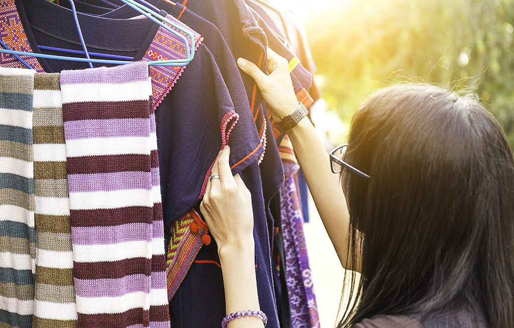 woman looking at a rack of clothes outside - how to dress over 50 