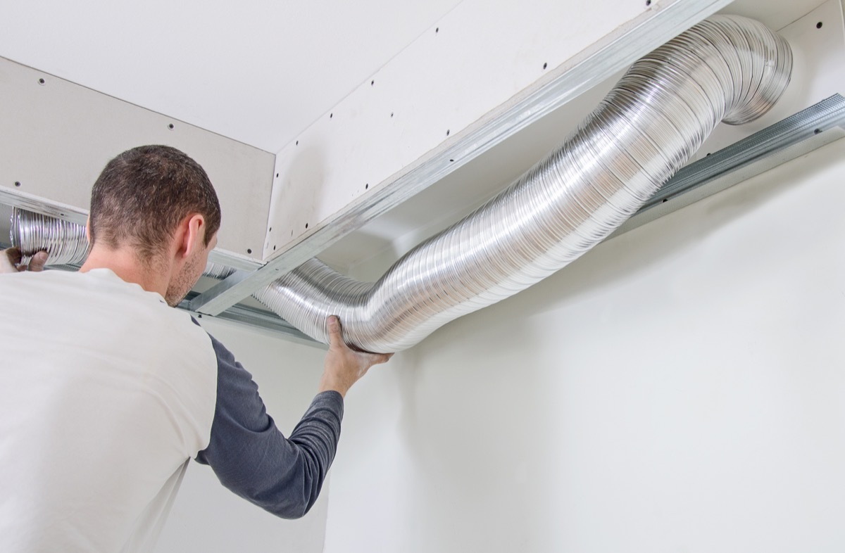 white man touching hvac system pipe